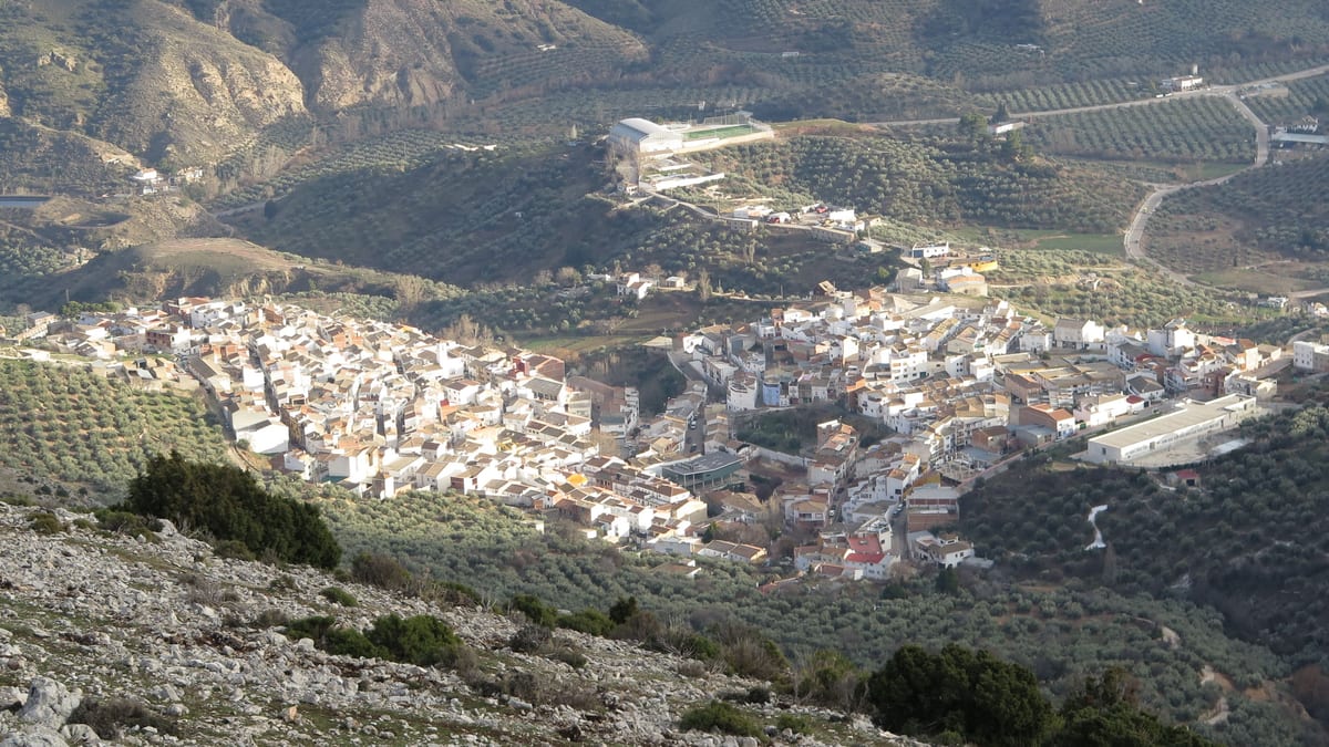 Pueblo blanco entre olivares y montes de Sierra Mágina, visto desde lo alto