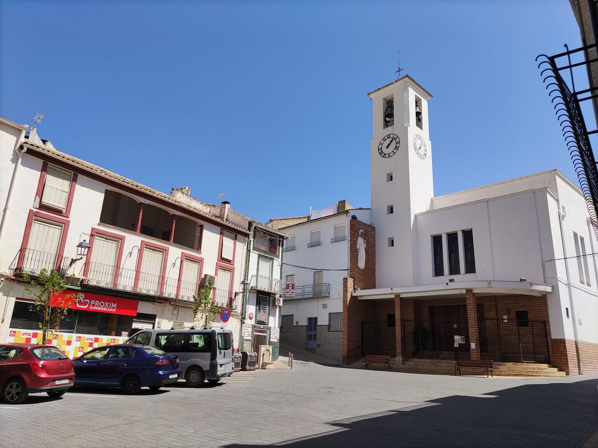 Plaza de Bélmez de la Moraleda con la iglesia parroquial blanca y su torre del reloj