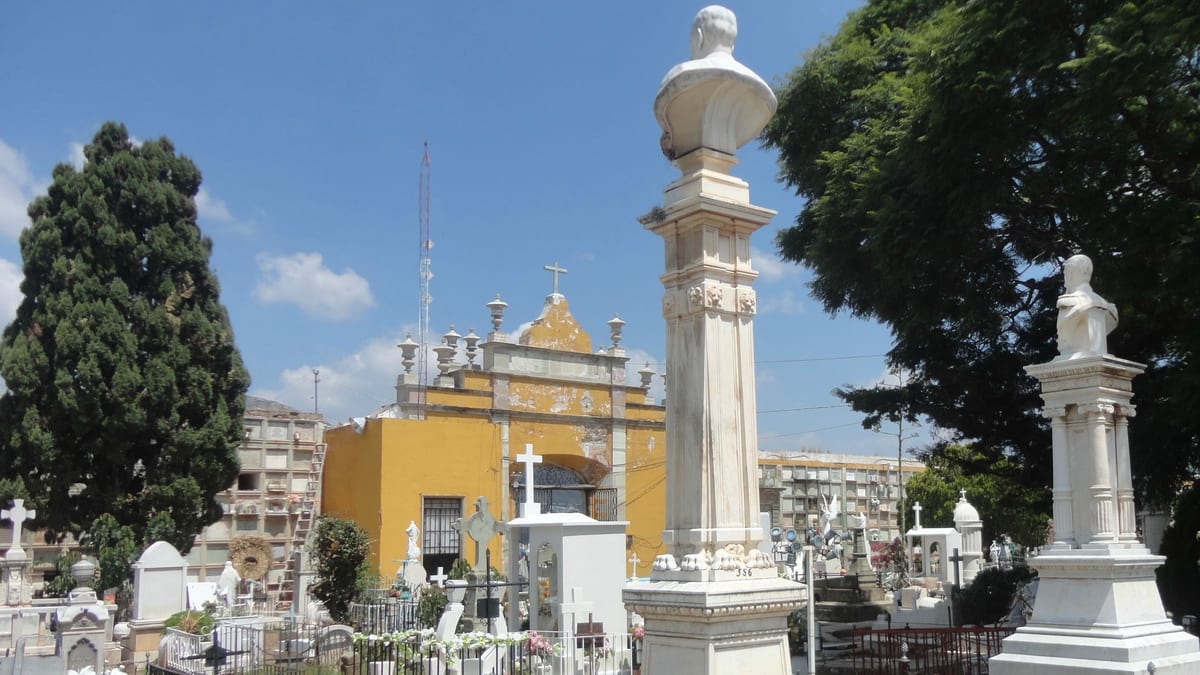 Panteón de Santa Paula en Guanajuato: capilla amarilla, tumbas blancas y al fondo los muros de nichos